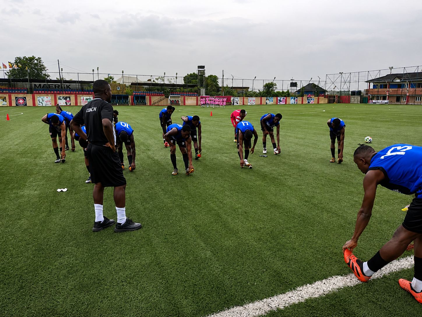Coach leading players through a warm-up session