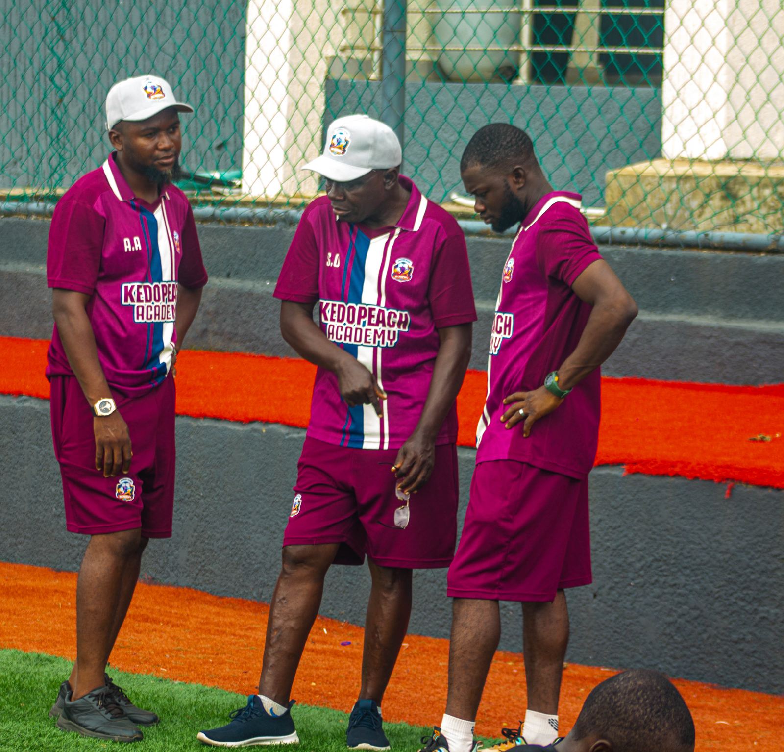 KEDOPEACH Academy coaching staff in discussion