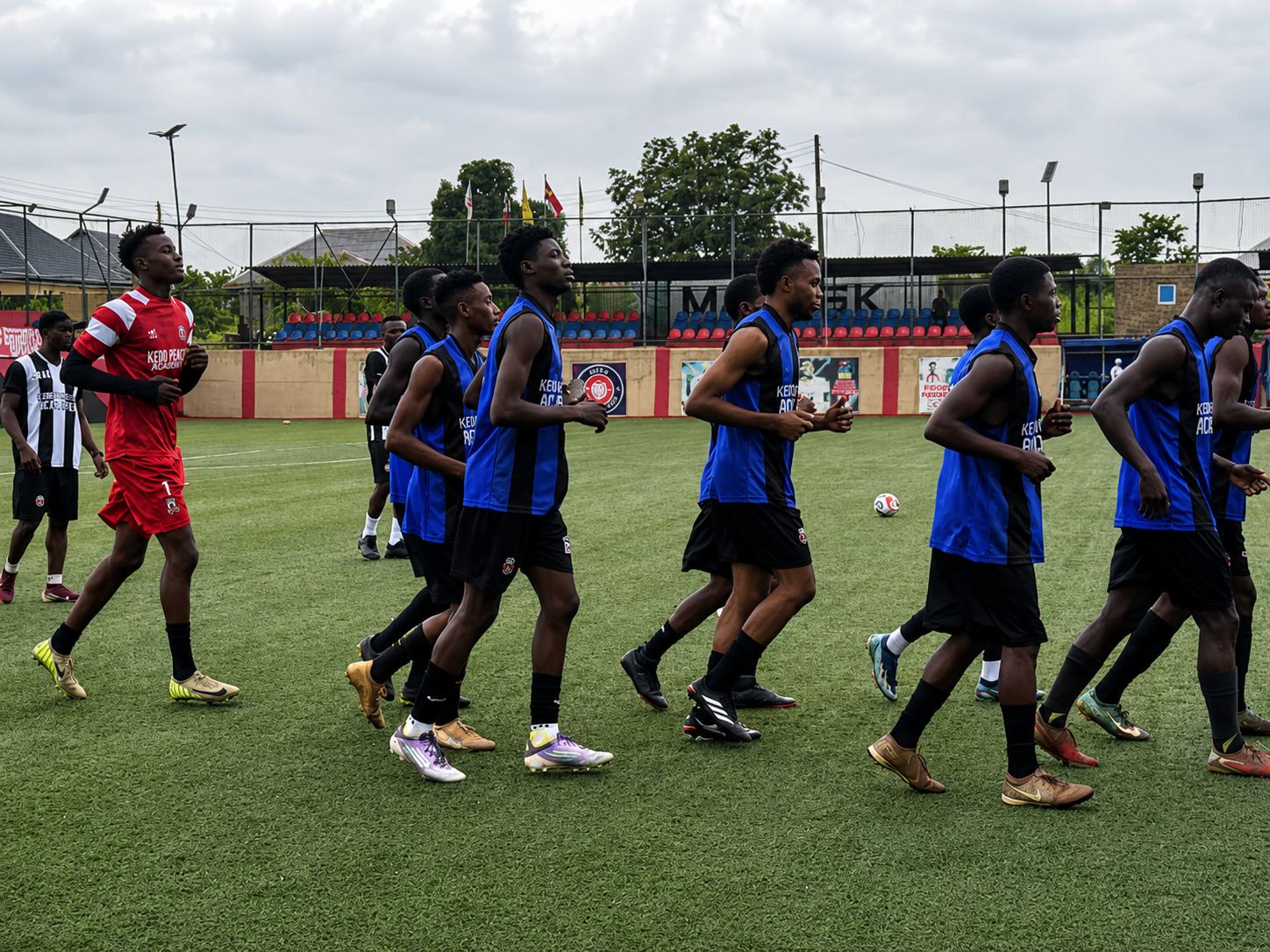 KEDOPEACH Academy players jogging during warm-up